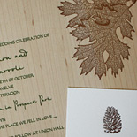 Alana and Matthew: wood veneer invitation with leaf, acorn, and pinecone motifs in moss and espresso